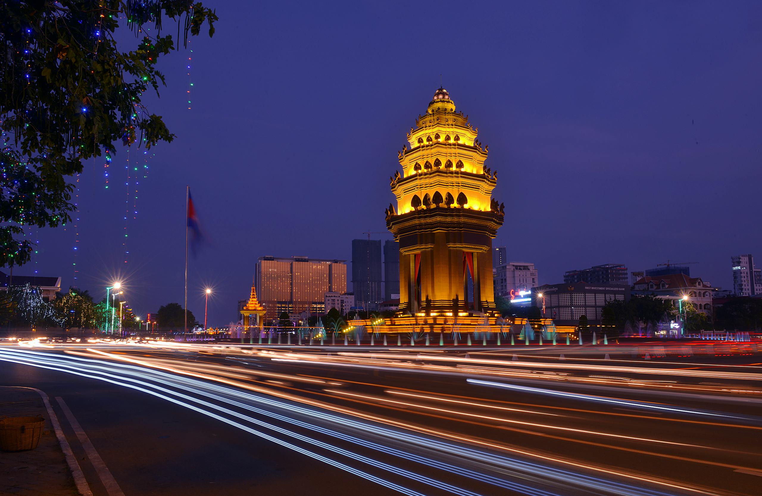 Long exposure night photograph of the illuminated Independence Monument with light streaks in Phnom Penh, Cambodia.