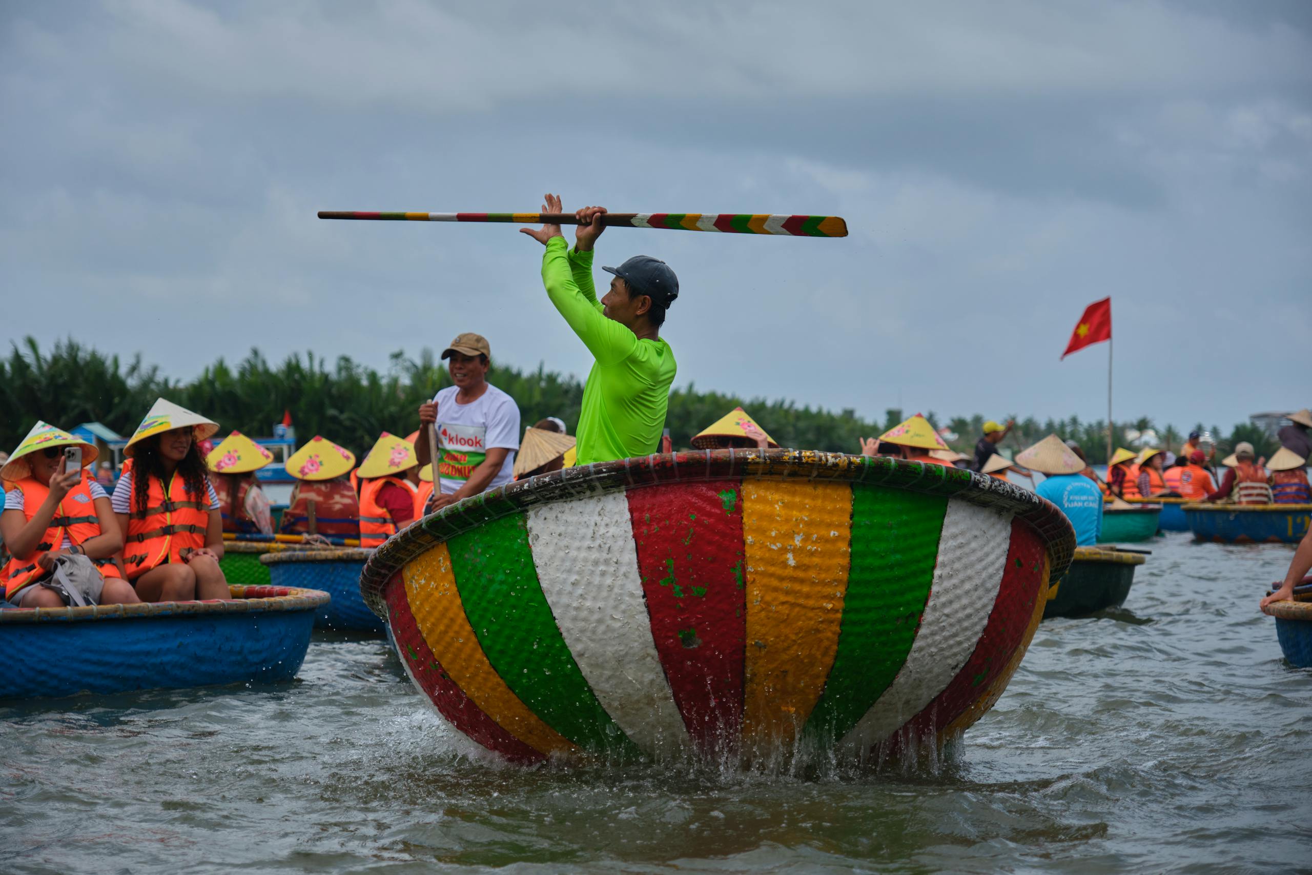 Tourists enjoy a spinning basket boat experience in Hội An, Vietnam, showcasing local culture.
